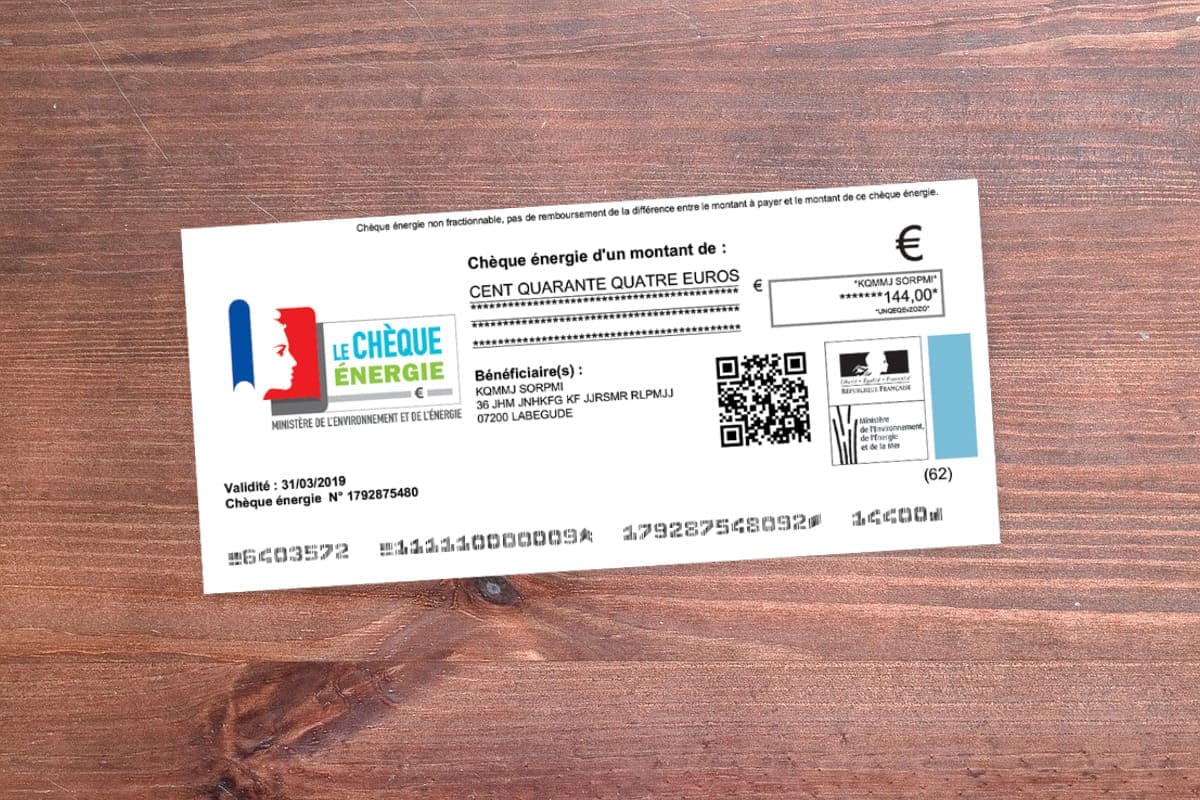 Un chèque énergie est posé sur une table en bois